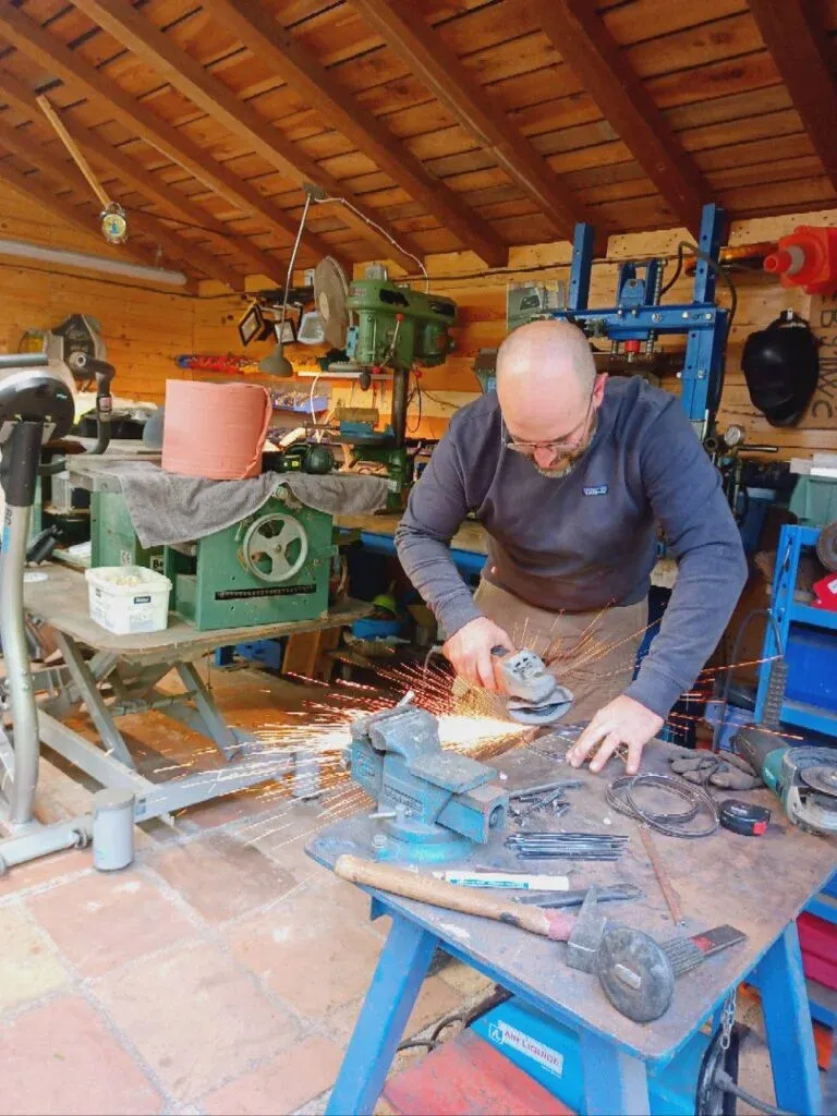 L’atelier : une main au travail sur une pièce de fontaine