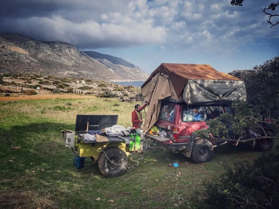 Le 4×4 avec sa tente de toit et sa remorque, au bord de la mer